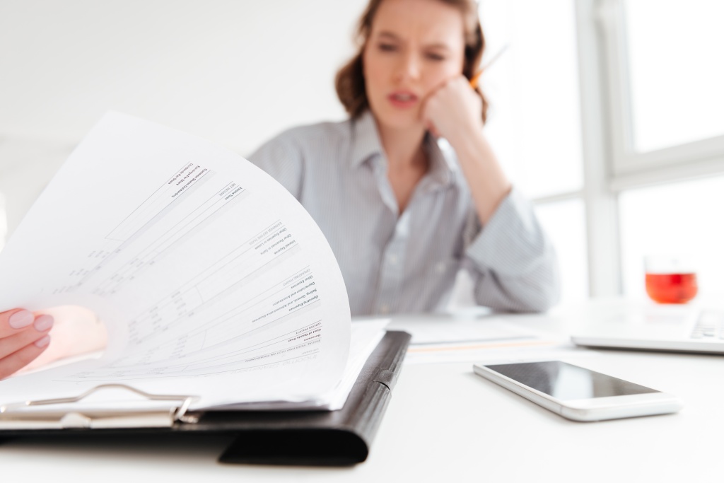 serious-brunette-woman-reading-papers-while-siting-workplace-light-aparment-selective-focus-document.jpg девушка